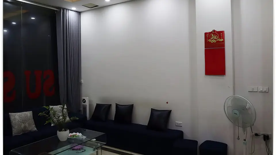 하노이 수 사우나 수 사우나의 다크 네이비 소파와 유리 테이블이 배치된 모던한 대기 라운지 내부
