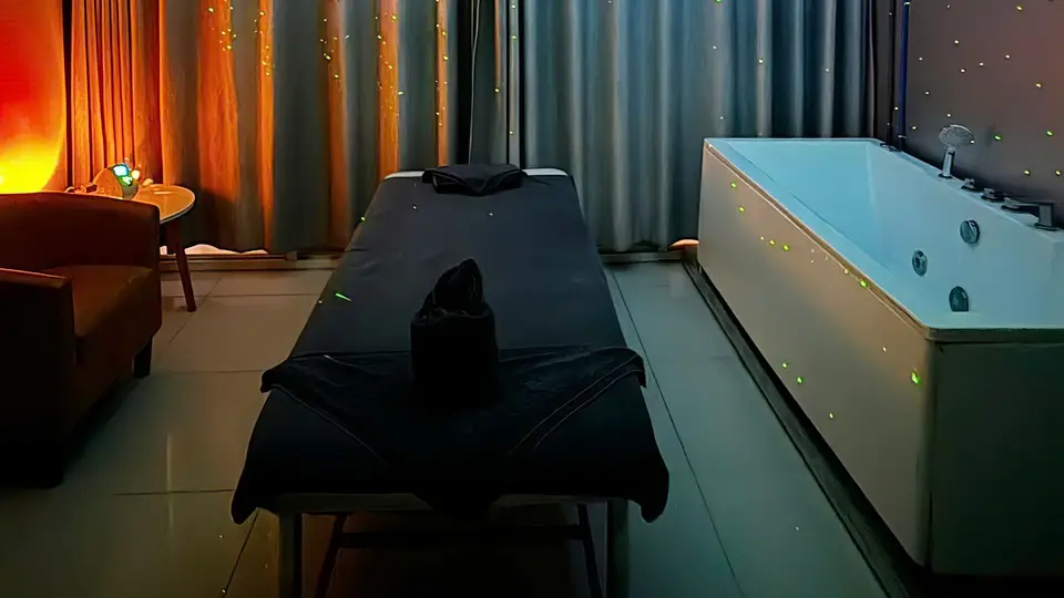 호치민 아리 스파 어두운 조명 속 블랙 마사지 베드와 LED 조명이 감싸진 대형 자쿠지 욕조가 배치된 스파 룸